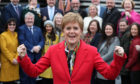 First Minister Nicola Sturgeon celebrates as she joins SNP's newly elected MPs for a group photo call outside the V&A Museum in Dundee.