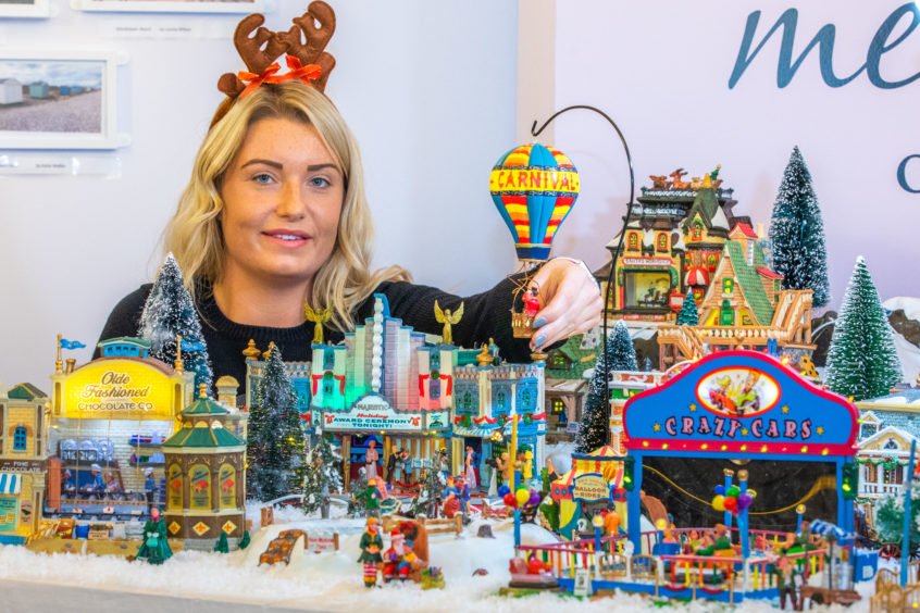 Staff member Abbie Durham with the model Christmas village.