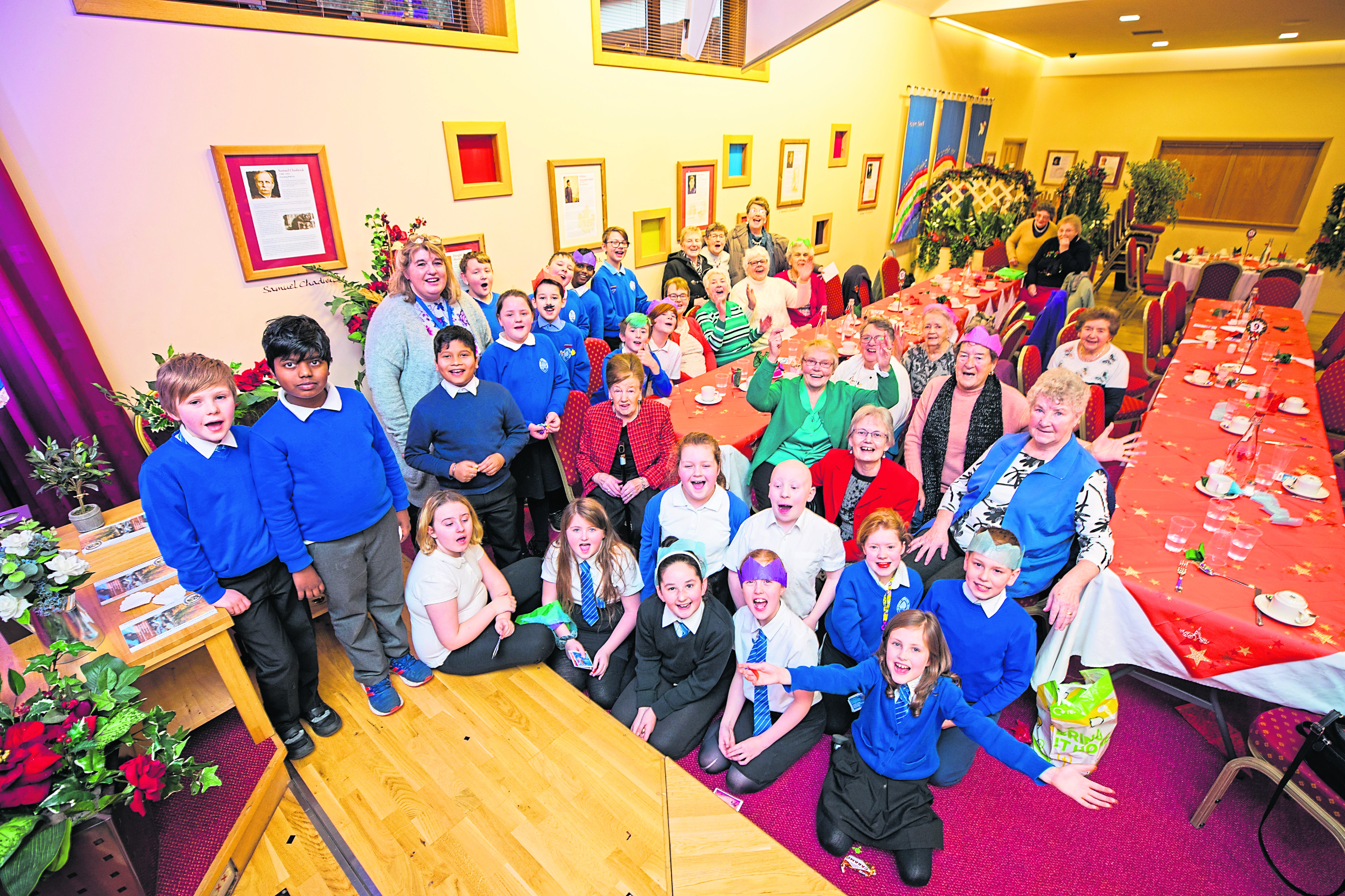 Children from St Ninians P5–6–7 and head teacher Sheona Glenville-Sutherland, back left, with Jane Milne, co founder and senior pastor, front right in red, and pensioners from the Letham area of Perth in the National Christian Outreach Centre, Riggs Road. Picture: Steve MacDougall.