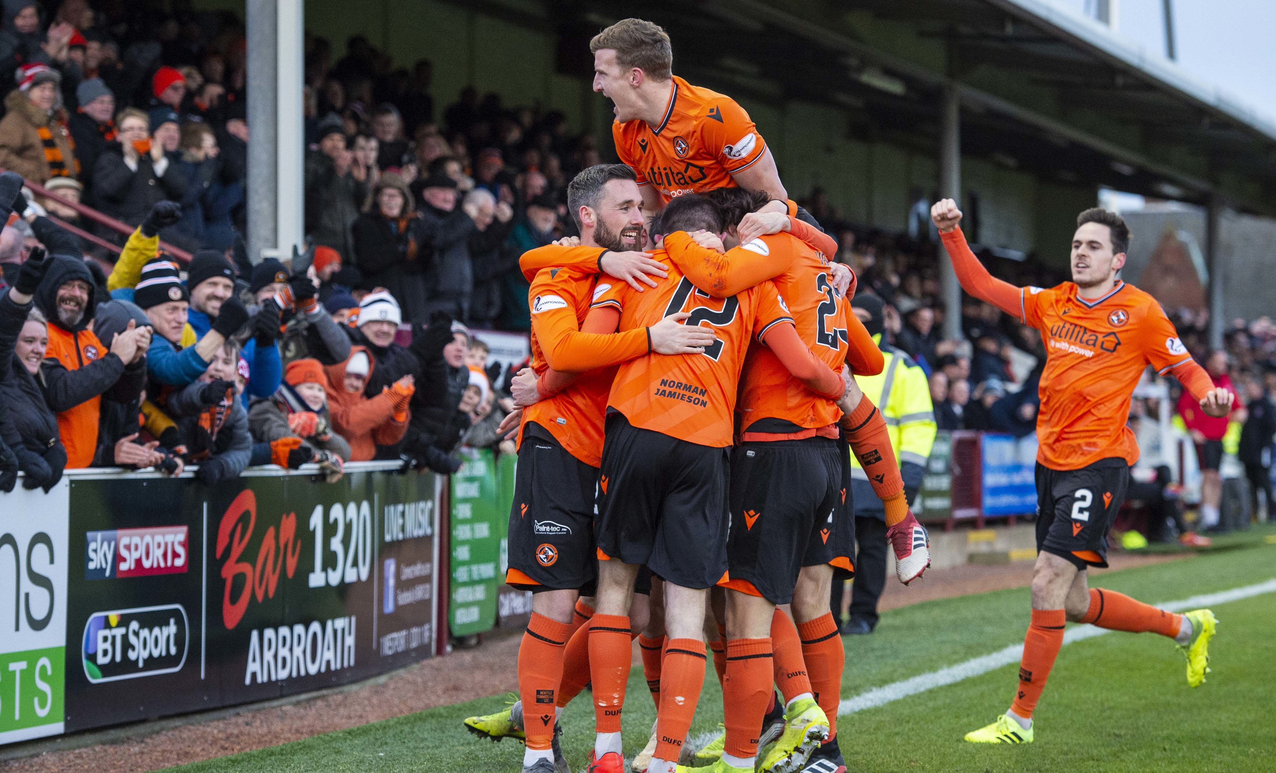 United number 12 Sam Stanton is mobbed after opening the scoring.