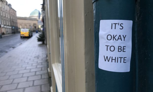 Stickers reading "Its okay to be white" have appeared around Perth.