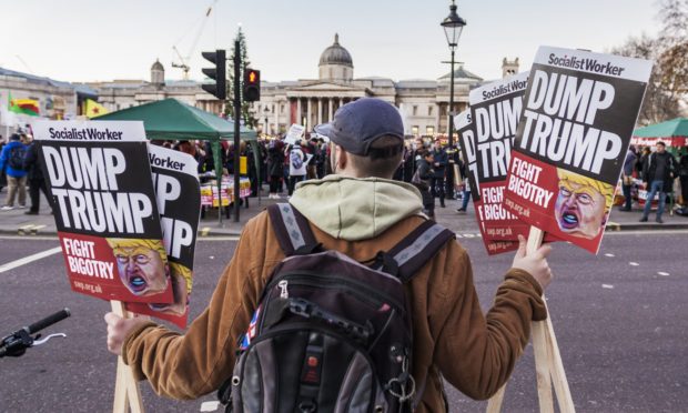 A protester holds anti-Trump banners in a demonstration in London.