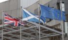 The flags of the United Kingdom, Scotland and the European Union outside The Scottish Parliament building.