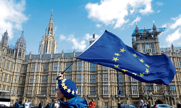 An anti Brexit campaigner shows her support for Europe waving a European Union flag outside Parliament in London in 2020