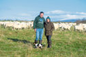 Neil and Debbie McGowan with Sky the Jack Russell and the flock of sheep.