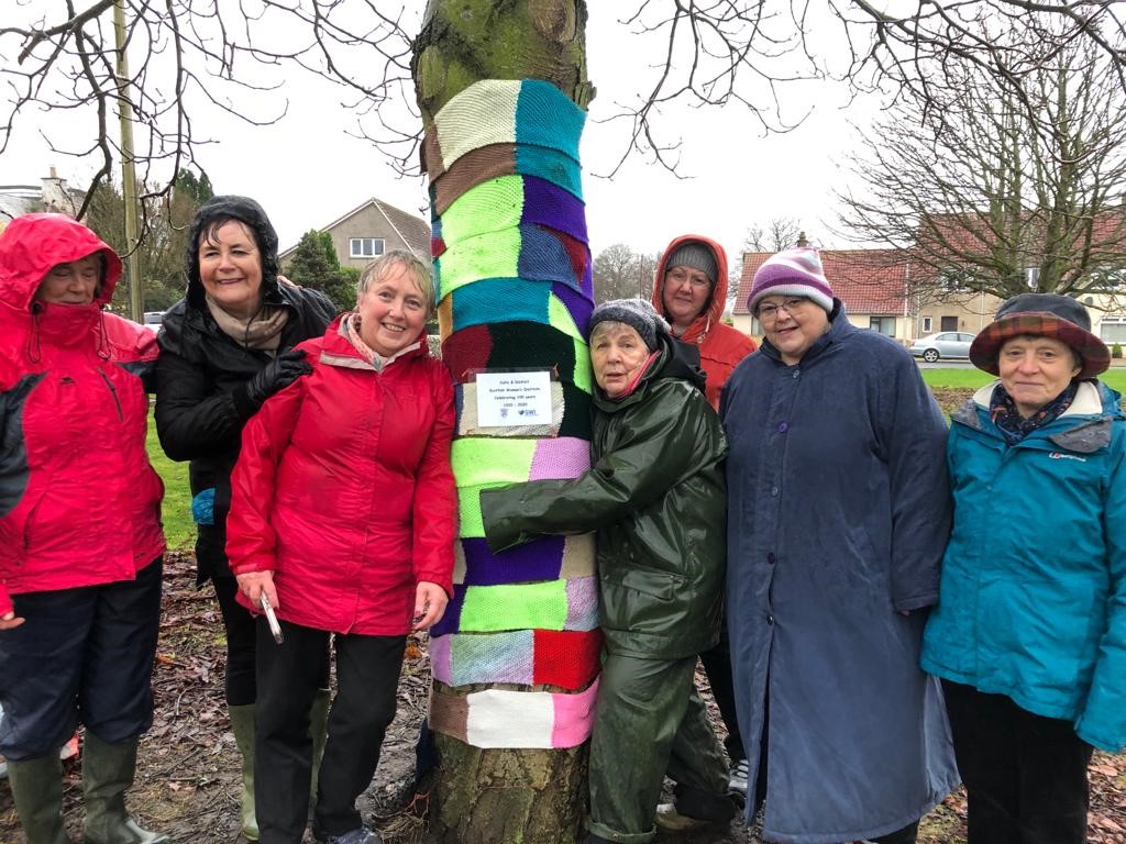 Members braved a wet afternoon to wrap the trees up warm.