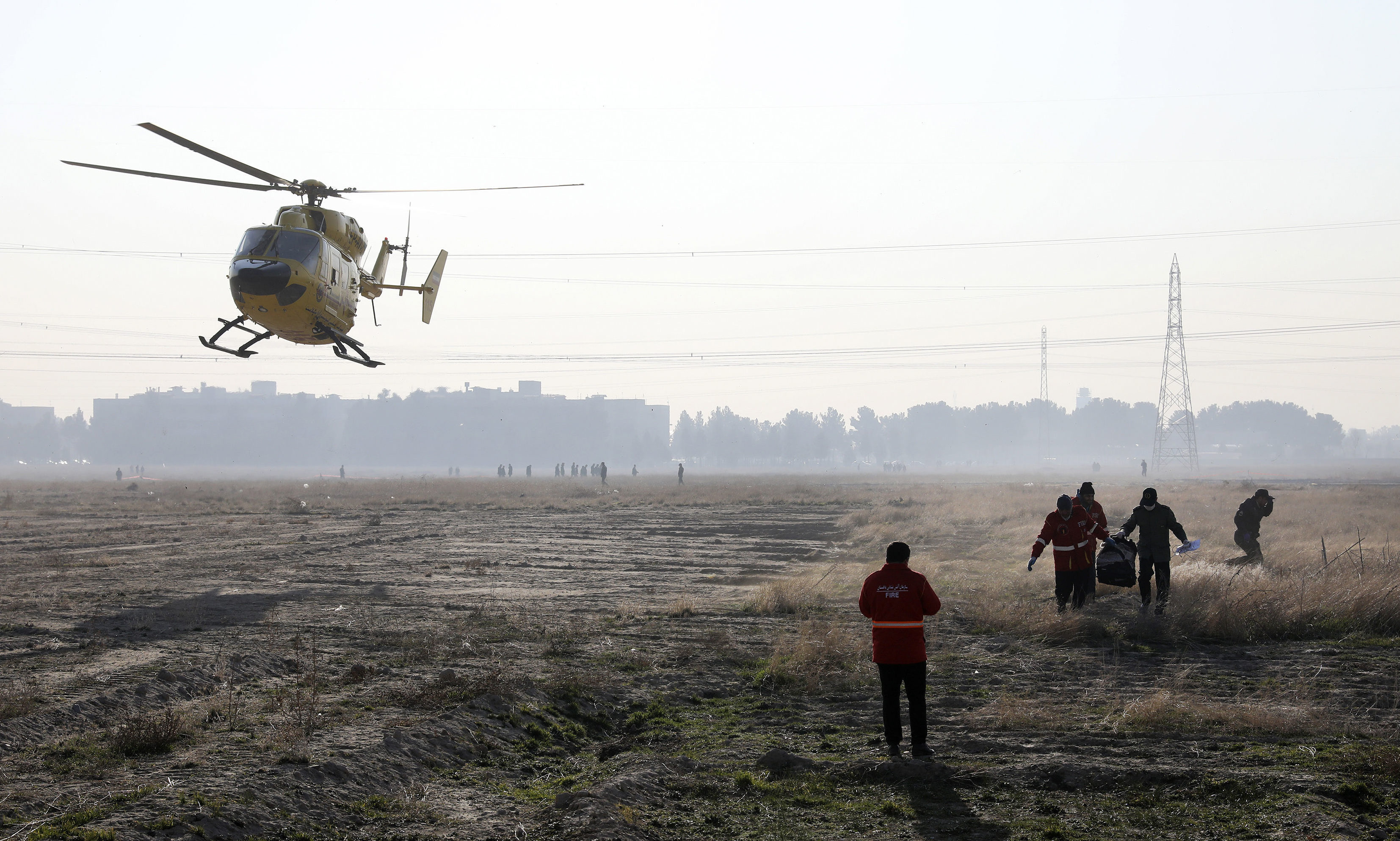 A rescue team work at the scene where an Ukrainian plane crashed in Shahedshahr, southwest of Tehran, Iran.