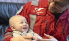 Paramedic Darren O’Brien holding baby James.
