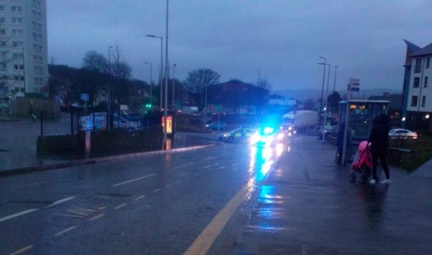 A police vehicle on Lochee High Street after a crash involving a bus and an elderly pedestrian.