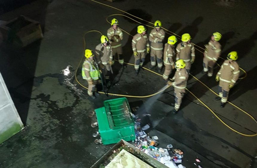 Firefighters tackle the bin fire at the foot of Pomarium Street flats, Perth.