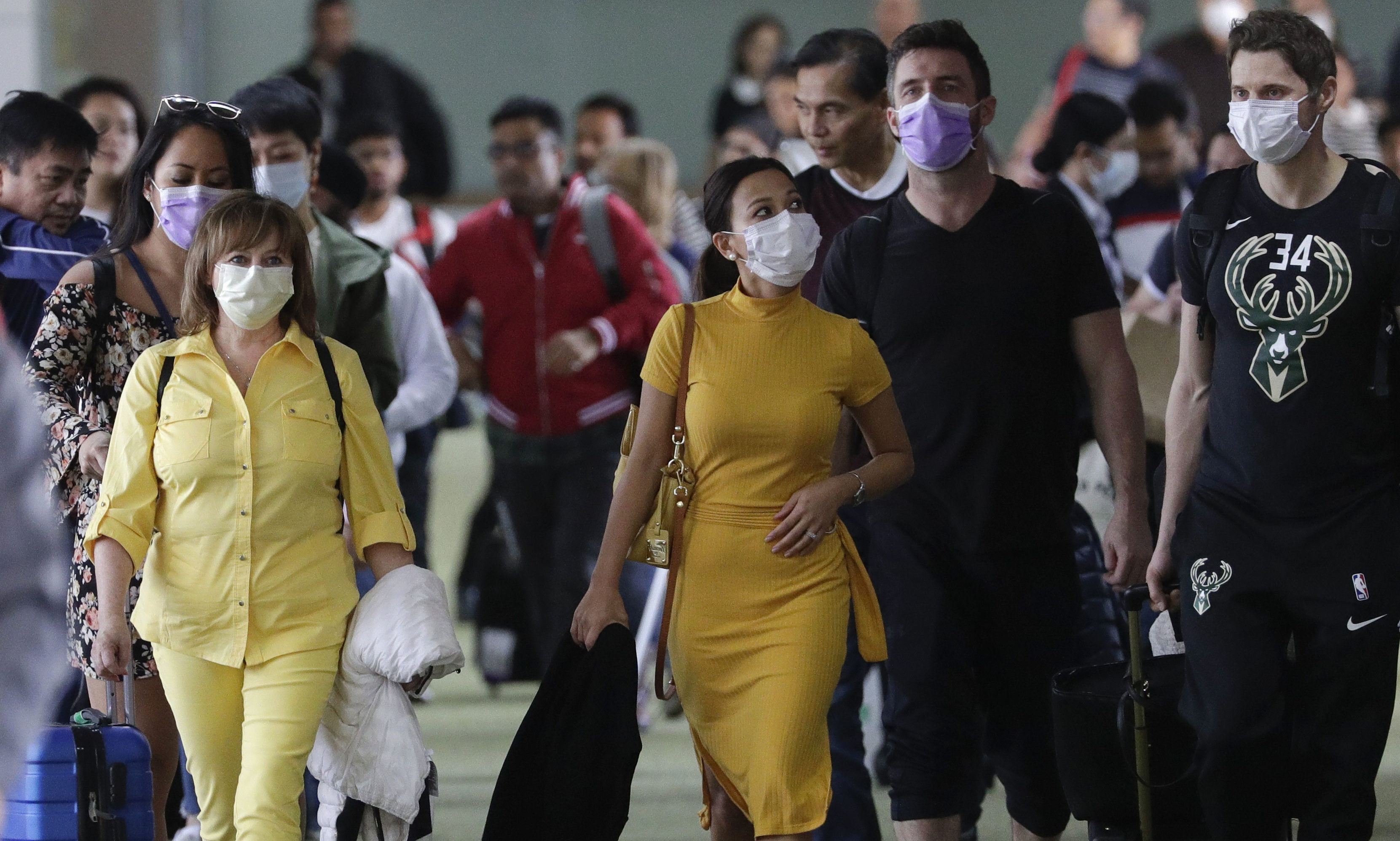 Passengers wear masks as they arrive at Manila's international airport, Philippines. The government is closely monitoring arrival of passengers as a new coronavirus outbreak in Wuhan, China has infected hundreds and caused deaths in that area.