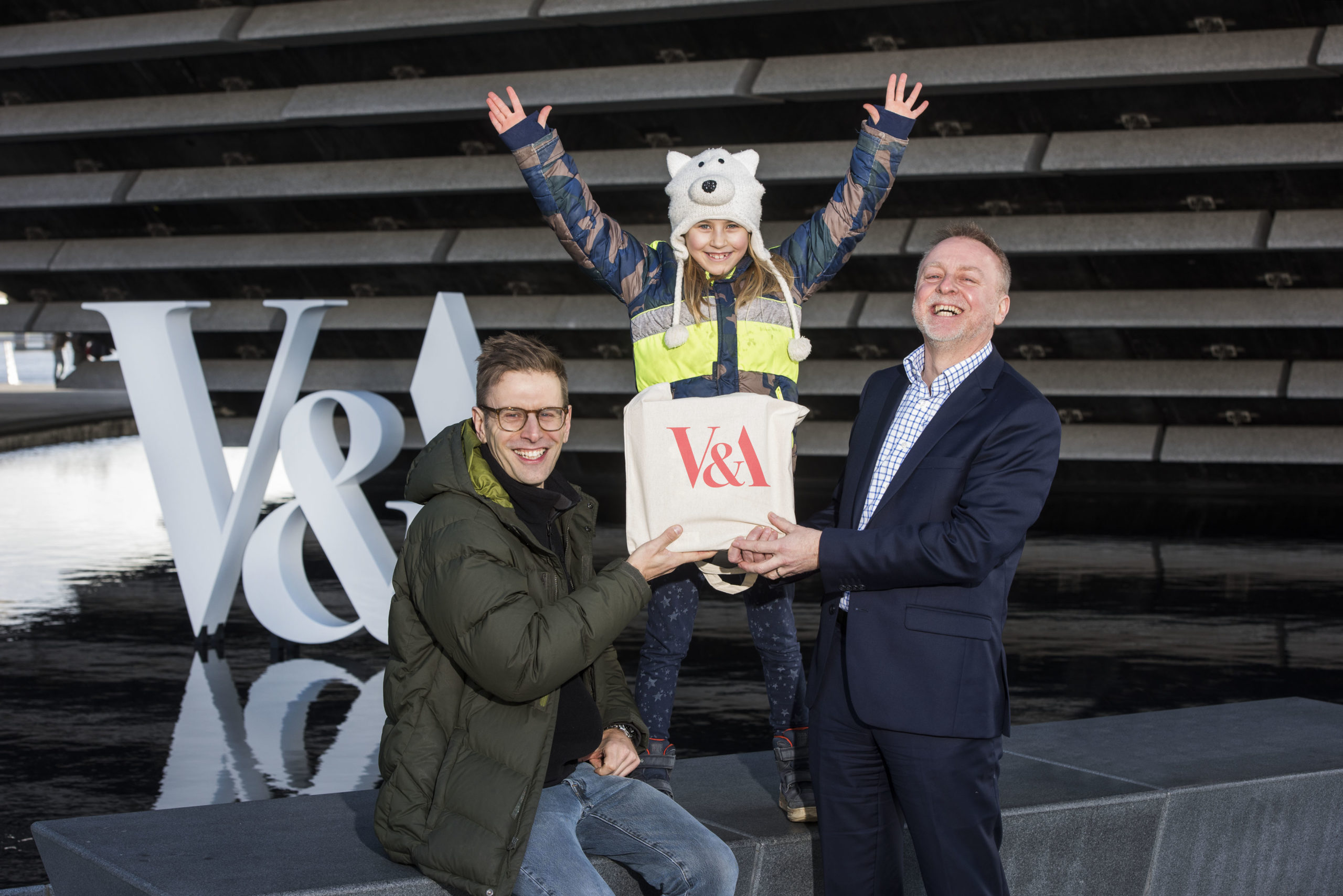 Philip Long, director of V&A Dundee, presents Jan Becker and his daughter Nalani, 7, from Berlin with a goody bag.
