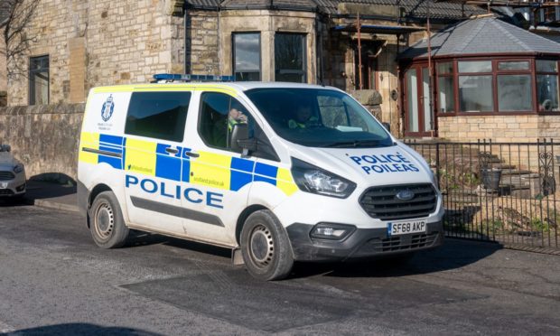 Police outside a property in Cardenden where a man is said to have been rushed to hospital via air ambulance after he fell of the roof.