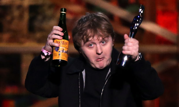 Lewis Capaldi with his Song of the Year award and a bottle of Buckfast on stage at the Brit Awards 2020 at the O2 Arena, London.