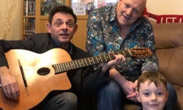 Alan Reed with the guitar signed by Steve Hackett, handing it over to Kevin O' Neil and son Nathan, 6.