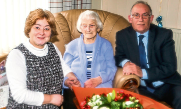 Councillor Fiona Grant presenting Mary with flowers on behalf of Fife Council, and Deputy Lord Lieutenant of Fife Colonel Jim Kinloch.