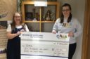Morna Milton-Webber presents the charity cheque to CHAS community fundraiser Emma Moore.