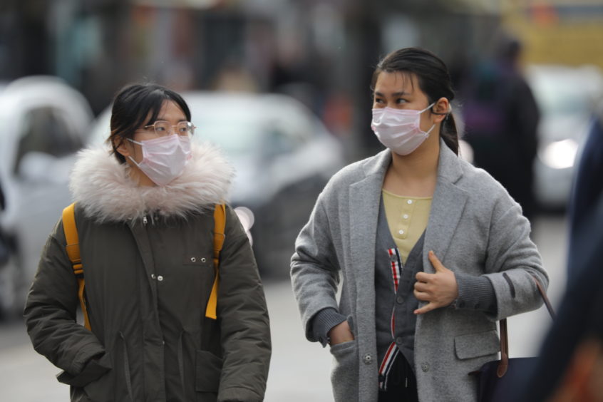 People wearing facemasks in Dundee as the country deals with the coronavirus outbreak.