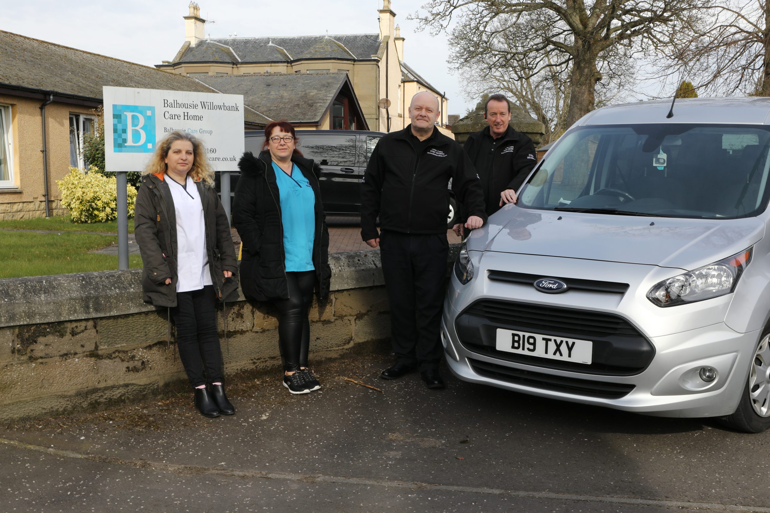 Joan Clements (senior carer) and Audrey Cant (care assistant) with Frank Brand and John McKenzie from Links Cabs, who are supplying free rides.