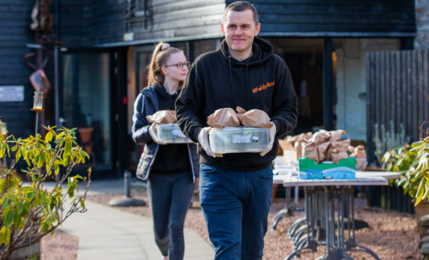Hot food delivery 'Feldy-Roo' in association with Gavin Price. -- people arrive to collect food and papers to deliver for the morning run. Picture shows Ross Menzies and daughter Sasha Menzies. Watermill Gallery, Mill Street, Aberfeldy.