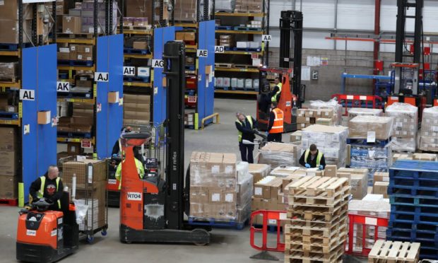 Workers gather supplies at the NHS' National Procurement Warehouse at Canderside, Larkhall, as deliveries of personal protective equipment (PPE) increased.