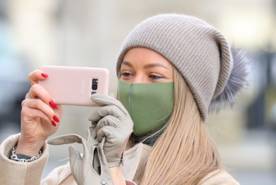 A woman wears a mask on Whitehall in Westminster, London.