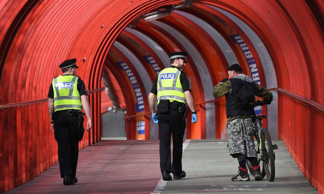 Two police officers on the tunnel bridge beside the SEC Centre are pictured amid the lockdown.