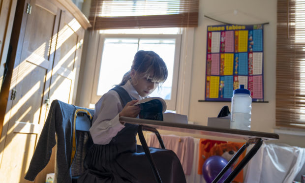 Emily, 9, sits at her desk at home on the first day of home schooling after schools shut on Friday due to the coronavirus pandemic.