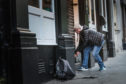 The shutters being drawn down at the Bank Bar in Dundee in March as the lockdown began.