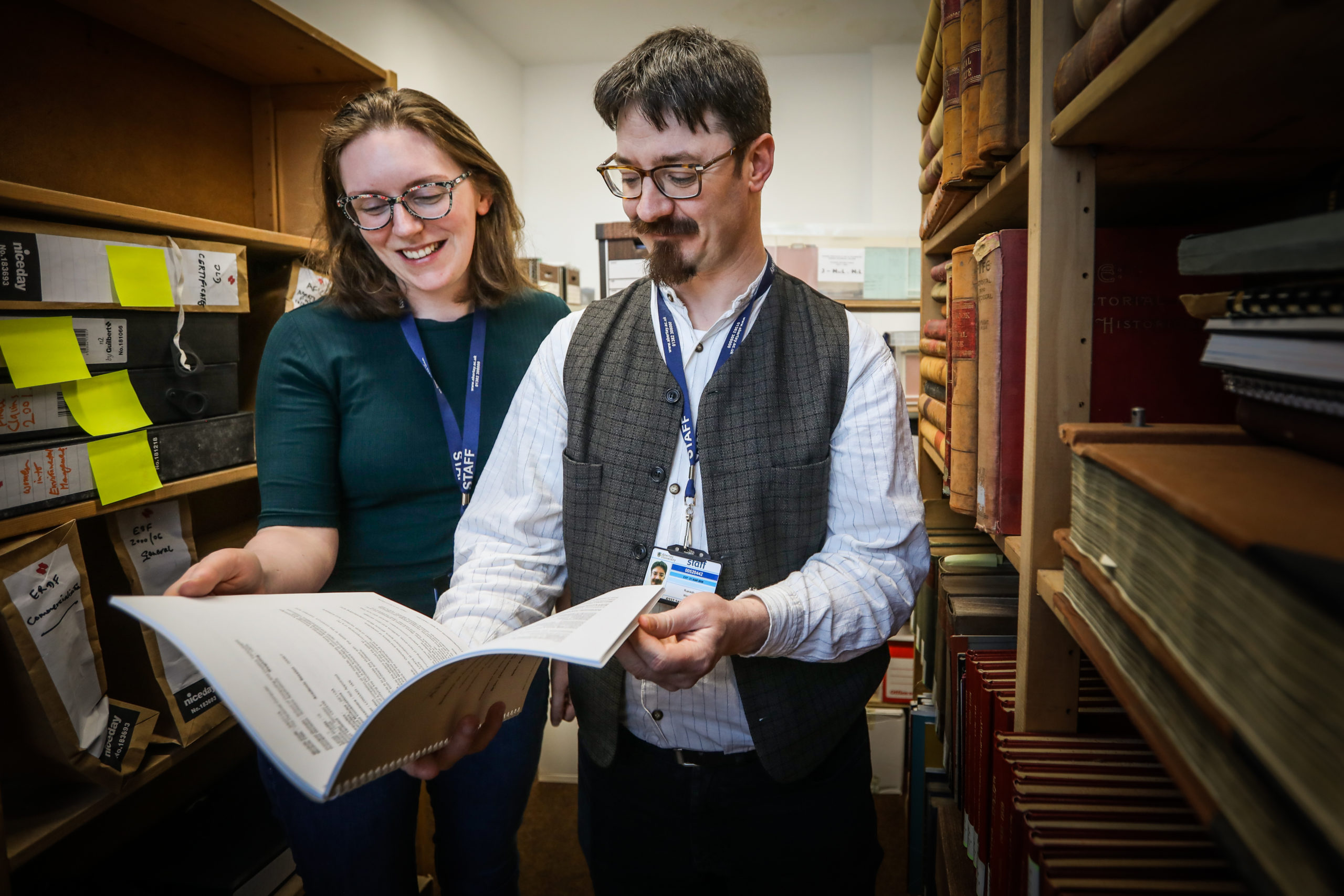Public Engagement Officer Hope Busàk with archivist Ruaraidh Wishart in the archive room with the Ethnical Hacking workbook.