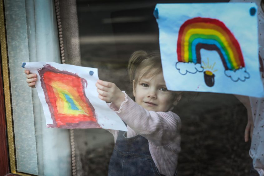 Meg Hann, 5, puts her rainbow in the window.