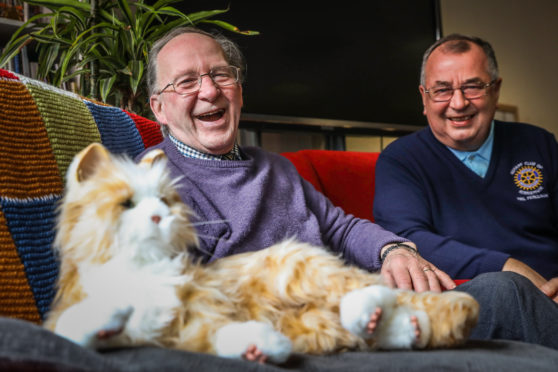 Kirrie Connections member Evan Duncan and Kirrie Rotary Club president Neil Ferguson with Kowka the robotic cat.