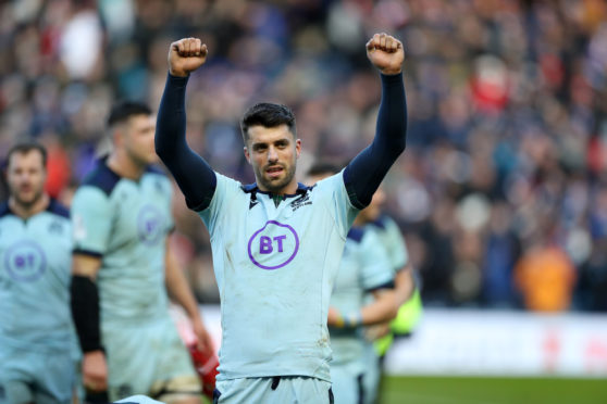 Adam Hastings celebrates at the end of Scotland's win over France.