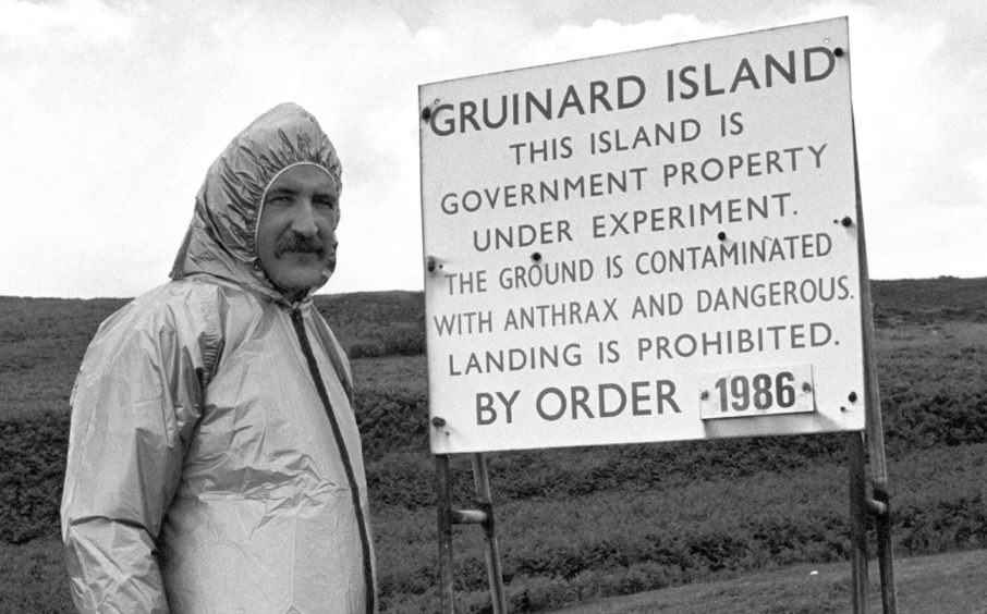 Malcolm Broster of MOD Chemical Defence Establishment at Porton Down, alongside one of the warning signs on the Gruinard Island.