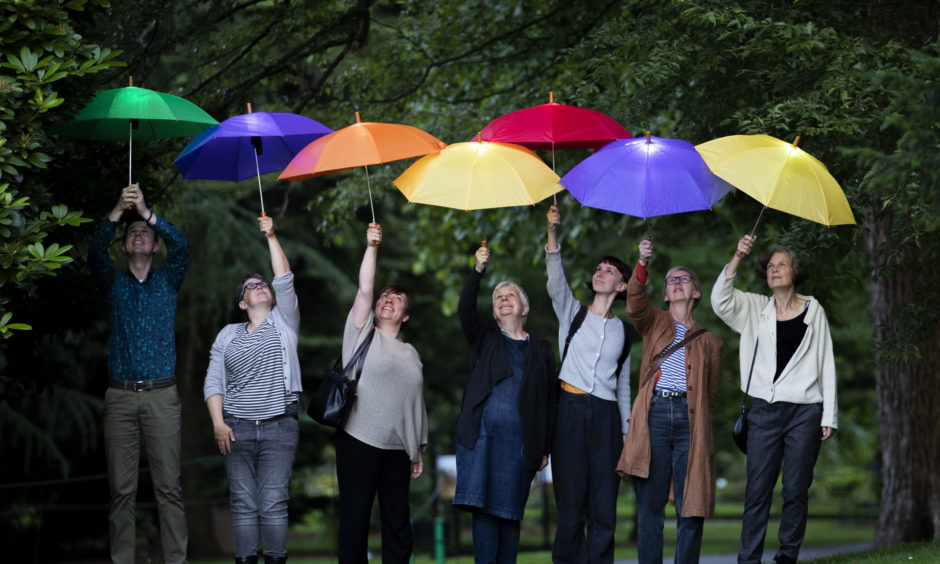 Visitors walk through the the Royal Botanic Garden Edinburgh at dusk with illuminated 'sonic umbrellas', which play birdsong from Caithness and Sutherland in 2019.