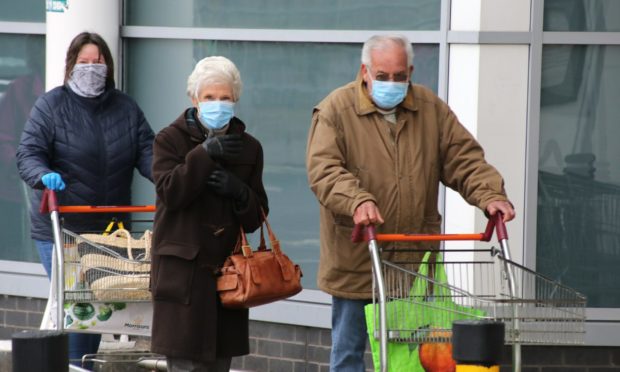 Evening telegraph news CR0020680  Coronavirus Covid-19 G Jennings pics elderly people queue to get in for their shopping at Sainsbury,s Dundee,friday 27th march.