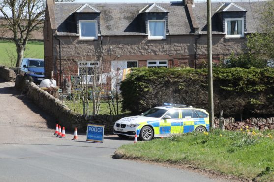 Police on the main road into Auchmithie after a cyclist died in an accident.