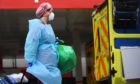 A member of hospital staff wearing personal protective equipment (PPE) outside St Thomas' Hospital in Westminster, London as the UK continues in lockdown to help curb the spread of the coronavirus.