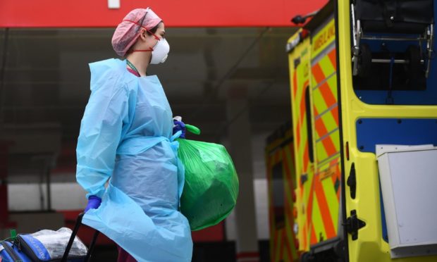 A member of hospital staff wearing personal protective equipment (PPE) outside St Thomas' Hospital in Westminster, London as the UK continues in lockdown to help curb the spread of the coronavirus.