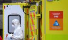 A paramedic wearing personal protective equipment (PPE) exits an ambulance outside St Thomas' Hospital in Westminster, London.