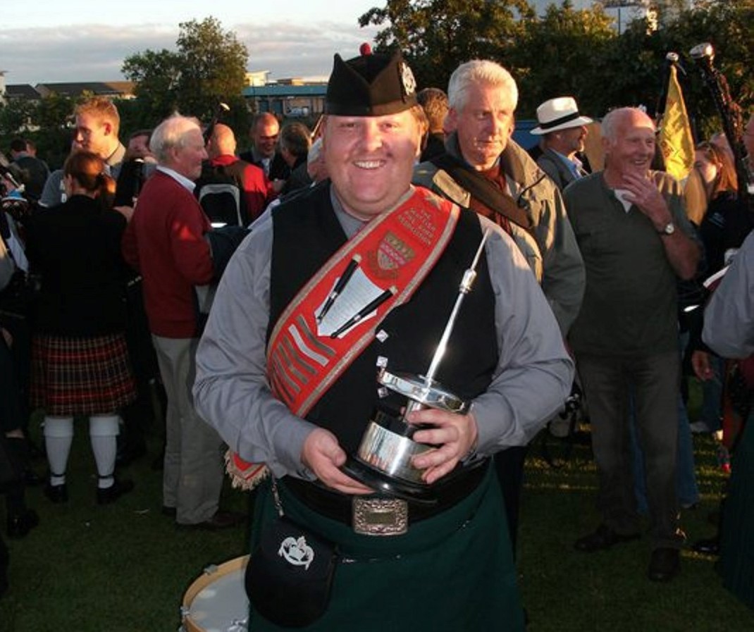 Renowned pipe band enthusiast Paul Brown with the World Pipe Band Championship trophy.