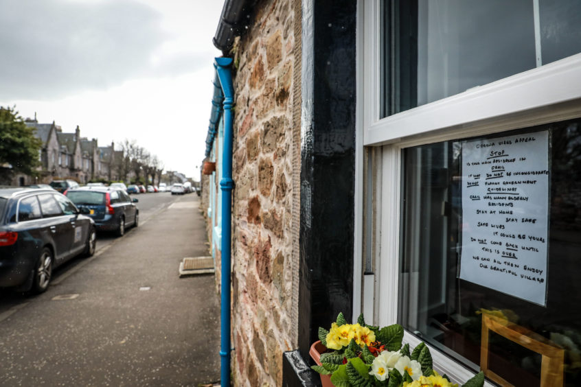 A poster in the window of a property in Crail directed to second home owners