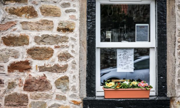 A poster in the window of a property in Crail directed to second home owners.