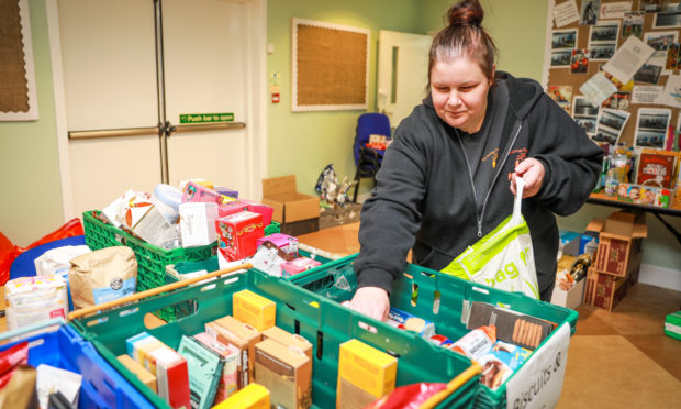 Volunteer Kirsty Hayston packs boxes of goods for clients.