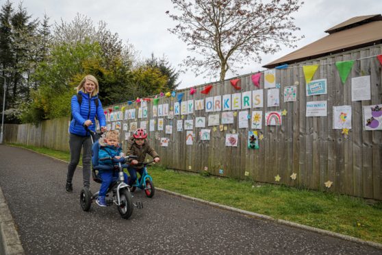 Tofthill residents, including Lisa Morris pictured with sons Rory, 3, and Austin, 1, are enjoying the estate's colourful wall of art.