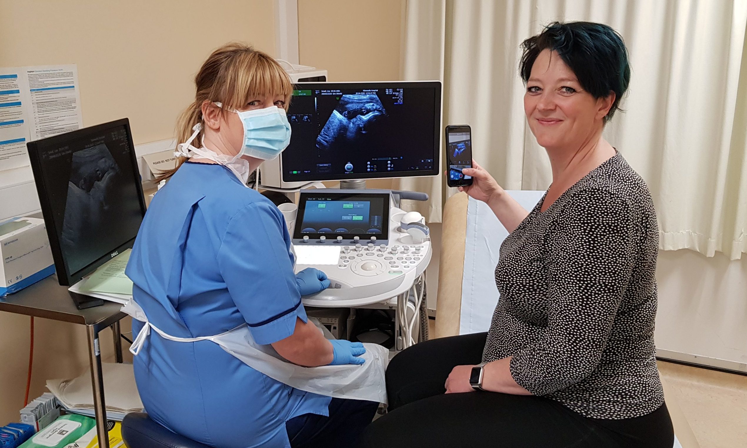 Midwife sonographer  Laura Coventry and mum-to-be Lisa Small with the scan of her baby.