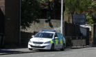 The police vehicle sitting on Dens Road in Dundee on May 6.