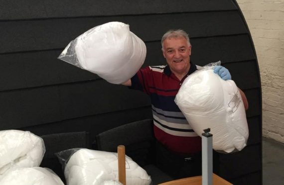 Celtic and Manchester United legend Lou Macari with the duvets sent by Fife firm Dusel Ltd.