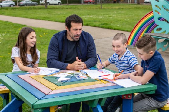 Montrose dad Mark Bradley using the activity packs with his children, Layla, Angus  and Oliver.