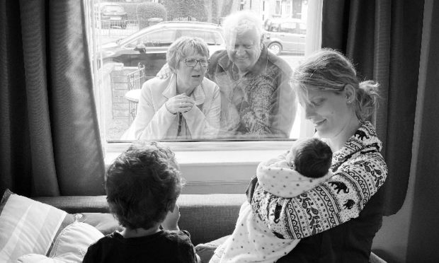 Baby Jørgen with his mother Caroline and brother Terje as they meet grandparents Ann and Alan.